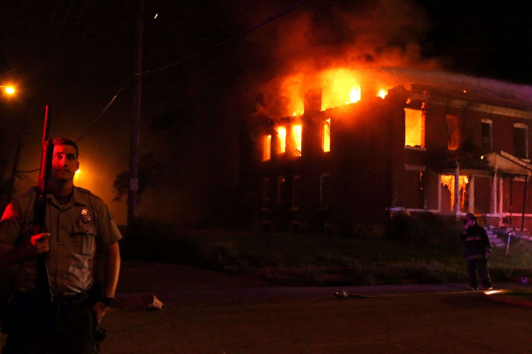 Officer guards firefighters at burning house on Bayard